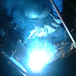 Welder from Miller UK Ltd fabricating the sculpture in the factory at Cramlington UK